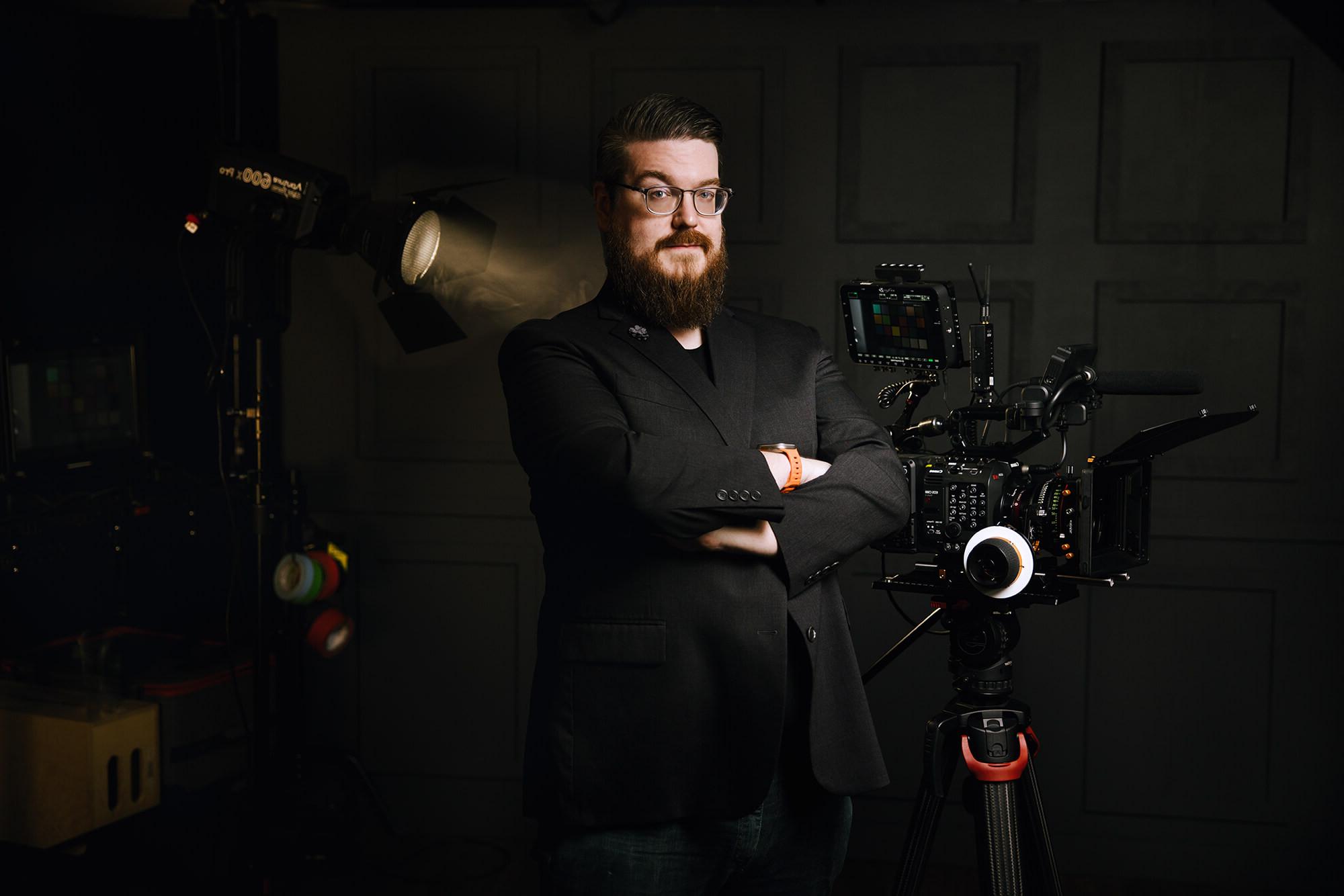 斯蒂芬·贝瑞斯的照片，他双臂交叉，站在电影制作设备周围.